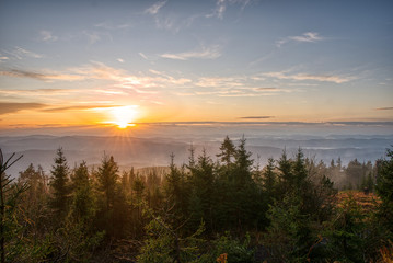 Fototapeta na wymiar Gorgeous sunrise with fog in the mountains with trees in the foreground, Czech, Lysa Mountain