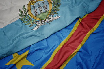 waving colorful flag of democratic republic of the congo and national flag of san marino.