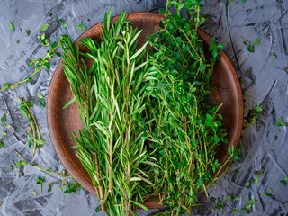 Bunch of rosemary and thyme on a clay plate top view