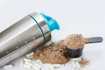 Shaker, scoop with protein powder and pills