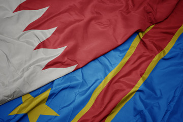 waving colorful flag of democratic republic of the congo and national flag of bahrain.