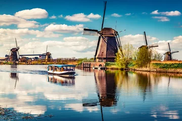 Fotobehang Walking boat on the famoust Kinderdijk canal with windmills. Old Dutch village Kinderdijk, UNESCO world heritage site. Netherlands, Europe. © Andrew Mayovskyy