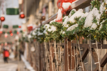 Decoration of wooden handrails Christmas tree twigs and luminous garlands and on the background of Christmas toys and lanterns..