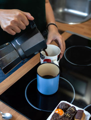 Close up of woman pouring coffee with italian coffee machine for two people. Overhead view.