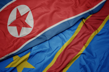 waving colorful flag of democratic republic of the congo and national flag of north korea.