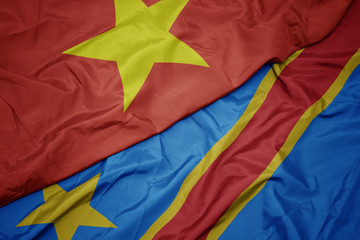 waving colorful flag of democratic republic of the congo and national flag of vietnam.
