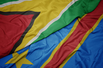waving colorful flag of democratic republic of the congo and national flag of guyana.