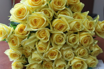 Many yellow roses in a table