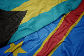 waving colorful flag of democratic republic of the congo and national flag of bahamas.