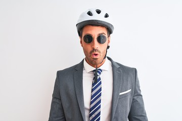 Young handsome business man wearing bike helmet and sunglasses over isolated background scared in shock with a surprise face, afraid and excited with fear expression