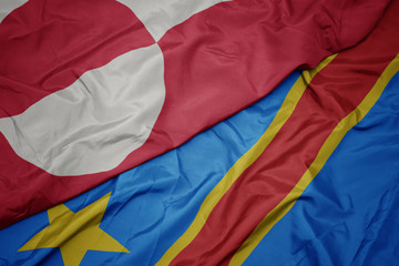 waving colorful flag of democratic republic of the congo and national flag of greenland.