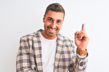 Naklejka premium Young handsome business man wearing elegant jacket over isolated background with a big smile on face, pointing with hand and finger to the side looking at the camera.