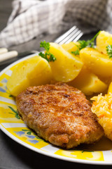 Minced pork cutlet served with potatoes and sauerkraut salad.