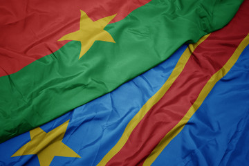 waving colorful flag of democratic republic of the congo and national flag of burkina faso.