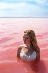 woman on a pink beach - obrazy, fototapety, plakaty