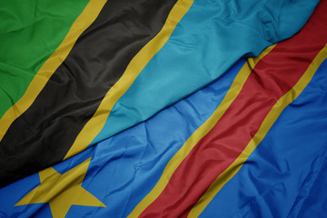 waving colorful flag of democratic republic of the congo and national flag of tanzania.