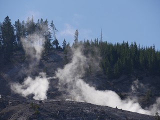 Fototapeta na wymiar Close up of steam rising from fumaroles at the Roaring Mountain at Yellowstone National Park, Wyoming.