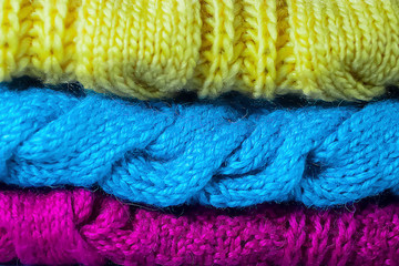 Knitted bright multi-colored things on a gray background. DIY things concept.