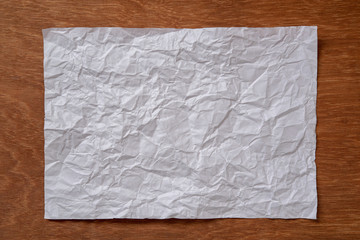 crumpled paper sheet on wood background
