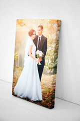 Wedding photo printed on canvas on white background. Sample of stretched wedding photography with...