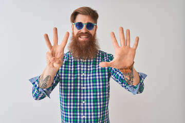 Young redhead irish man wearing casual shirt and sunglasses over isolated white background showing and pointing up with fingers number eight while smiling confident and happy.