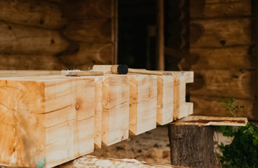 Brush and mallet on a wooden bar. construction of a wooden house