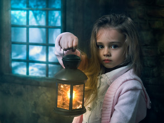 A little girl with a lantern by an old window. The concept of fairy tale, fantasy,
