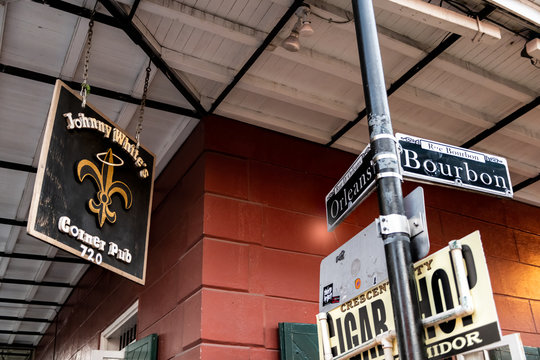 New Orleans, USA - April 22, 2018: Orleans and Bourbon Streets Sign intersection text at night with Johnny White's corner pub