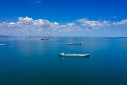 Aerial view of many cargo ships waiting for port entrance