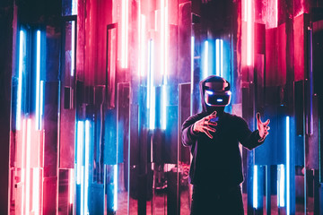 Man using VR headset of augmented reality and moving hands in air like stretching virtual frame in...