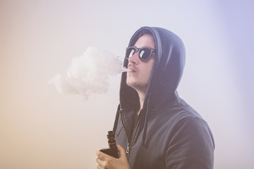 Vaping man with vaporizer and a cloud of vapor