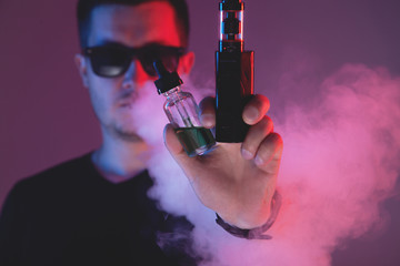 Vaping man with vaporizer and a cloud of vapor