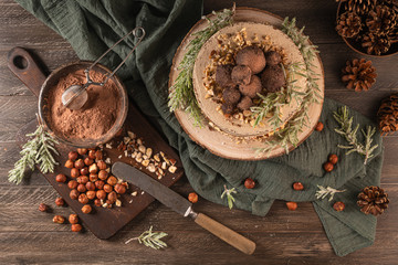 Delicious naked chocolate and hazelnuts cake on table rustic wood kitchen countertop. Top view. Flat lay
