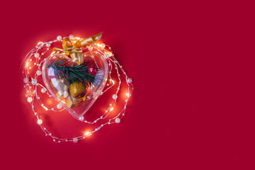 Heart box with garland on red background.