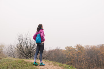 Woman tourist with small backpack in forest