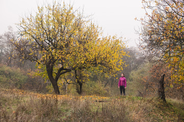 Sportive woman in pink jacket stand outdoors