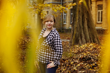 girl in a plaid shirt on a background of autumn leaves