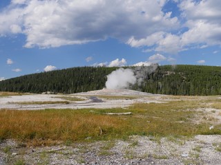 Breathtaking view of the Old Faithful geyser beginning to erupt early in the morning at Yellowstone...