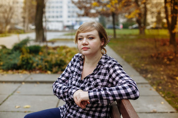 girl in a plaid shirt on a background of autumn leaves