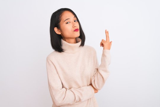 Young chinese woman wearing turtleneck sweater standing over isolated white background Shooting and killing oneself pointing hand and fingers to head like gun, suicide gesture.