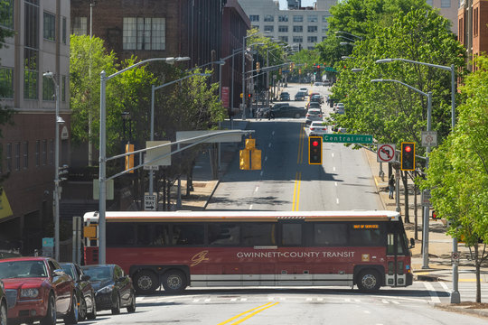 Atlanta, USA - April 20, 2018: Public transportation bus of Gwinnett county transit authority crossing intersection of Central avenue in downtown of Georgia city