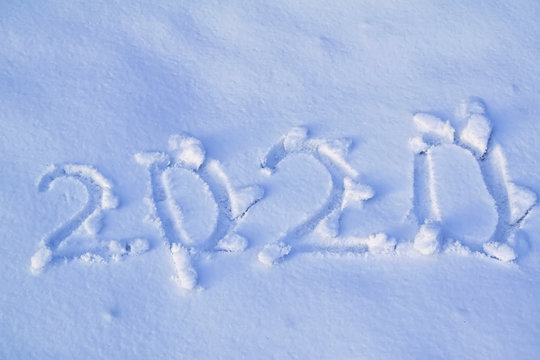 Digits 2020 written in the snow. Winter holiday concept.
