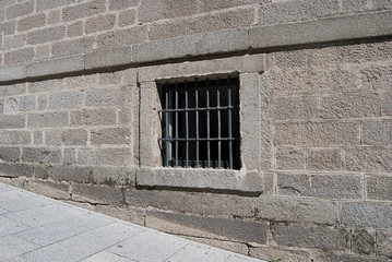 Window with bars on stone wall