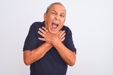 Senior grey-haired man wearing black casual polo standing over isolated white background shouting and suffocate because painful strangle. Health problem. Asphyxiate and suicide concept.