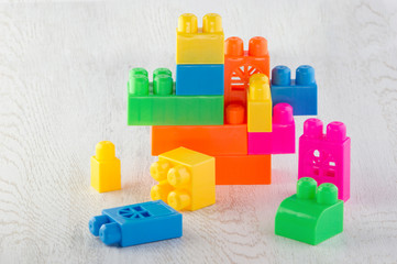  details of the children's designer of different colors and shapes folded on each other on a wooden tabletop