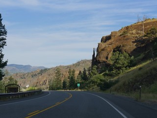 Winding road with the Chimney Rock, an imposing rock formation along North Fork Highway to Yellowstone National Park.