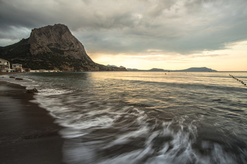 Waves of the Black Sea in a bay between the mountains, the beach