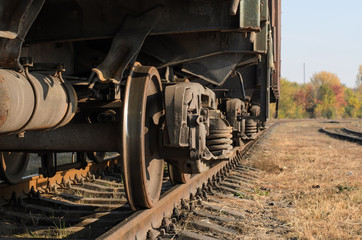 Fototapeta na wymiar Freight car (boxcar), angled view of chassis, suspension and metal wheels, close-up