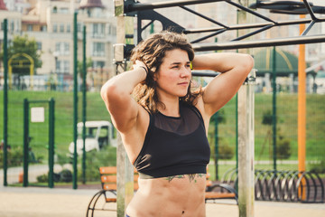 Attractive fit young woman in sport wear rest on the street workout area. The healthy lifestyle in...