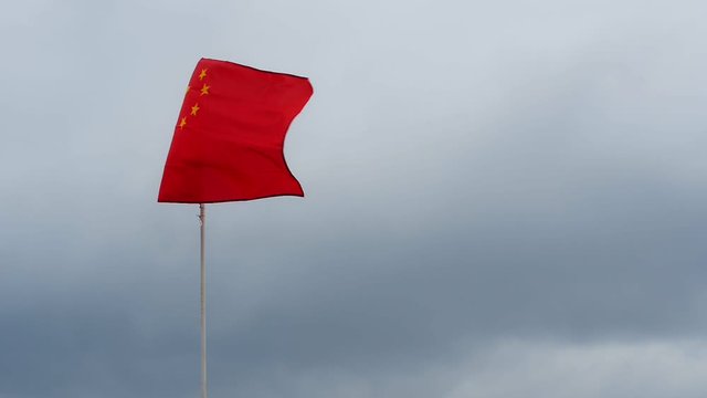 flag China, which flutters in the wind against a cloudy sky, the flag is unstable left or right doubt. concept inability to make decision indecision weak position